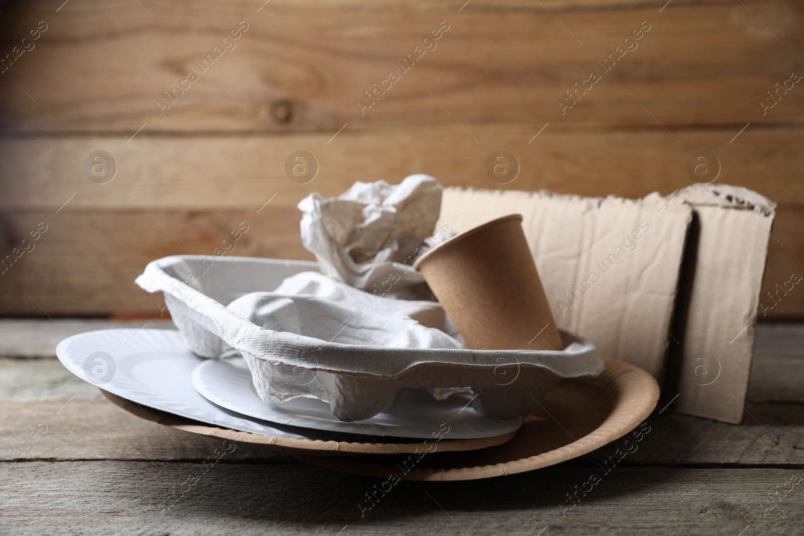 Photo of Different waste paper on wooden table near wall