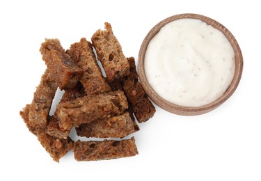 Delicious crispy rusks and sauce on white background, top view