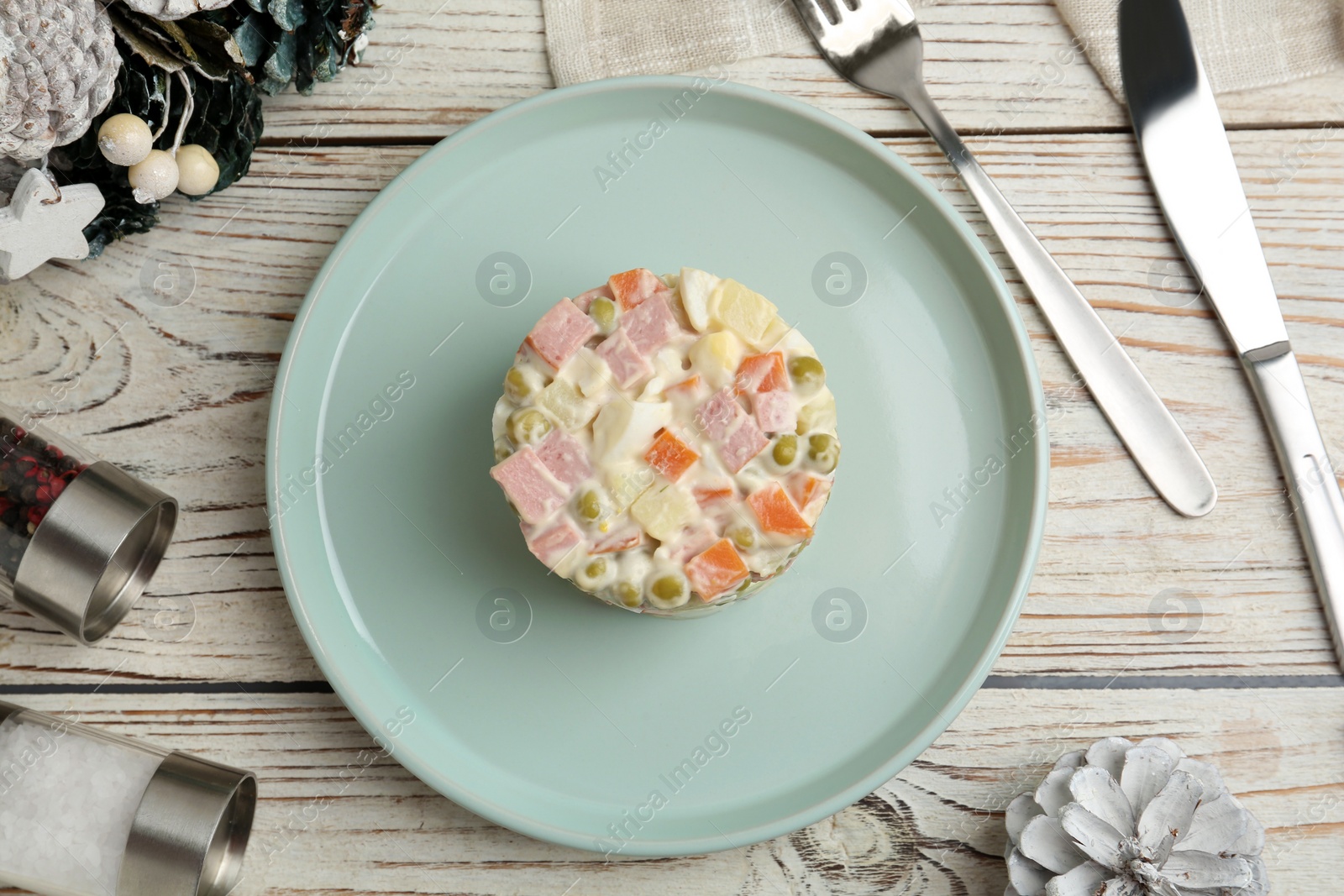 Photo of Traditional russian salad Olivier served on white wooden table, flat lay