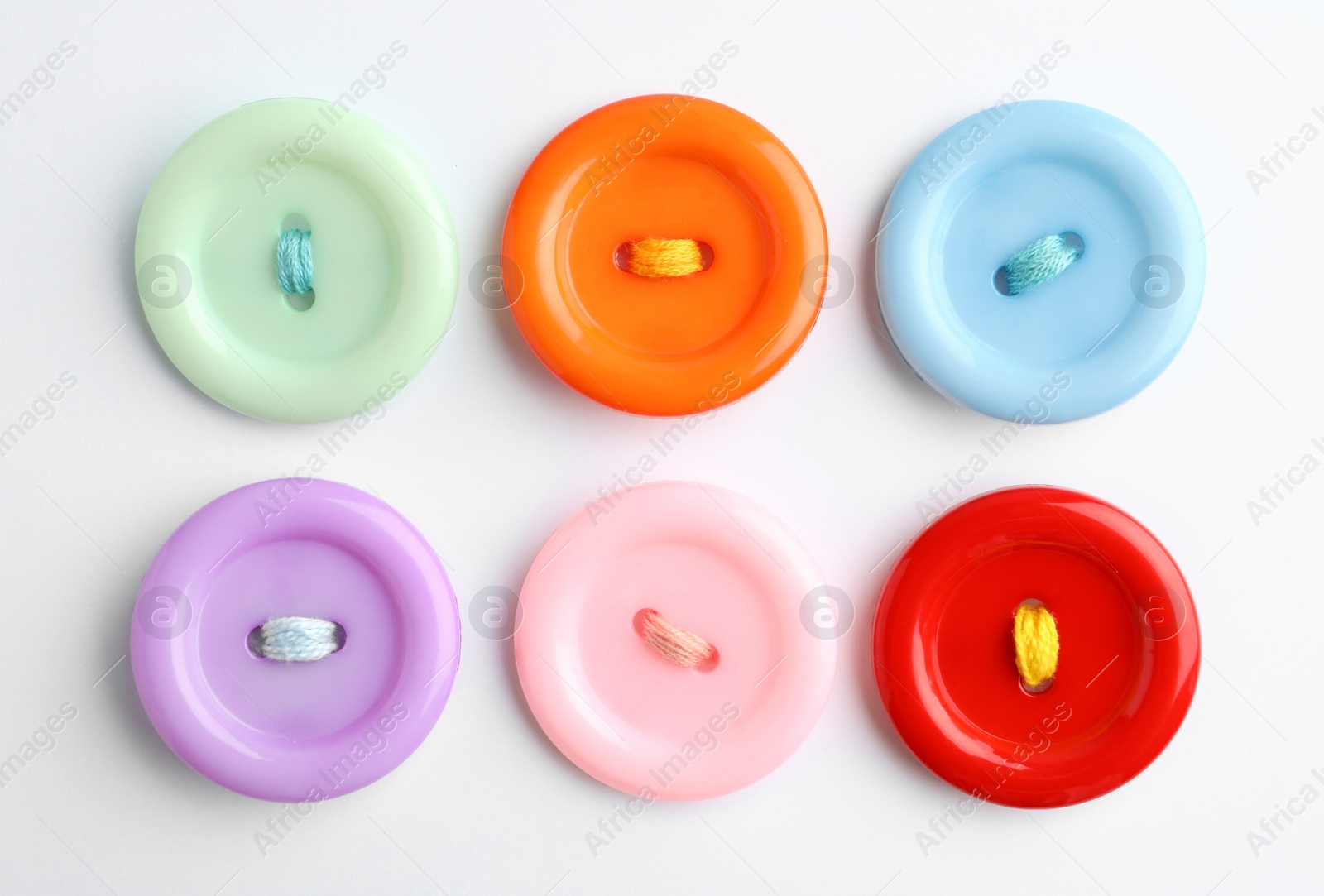 Photo of Many colorful sewing buttons on white background, top view