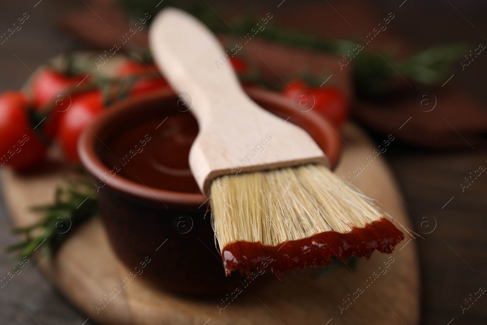 Photo of Marinade in bowl and basting brush on table, closeup