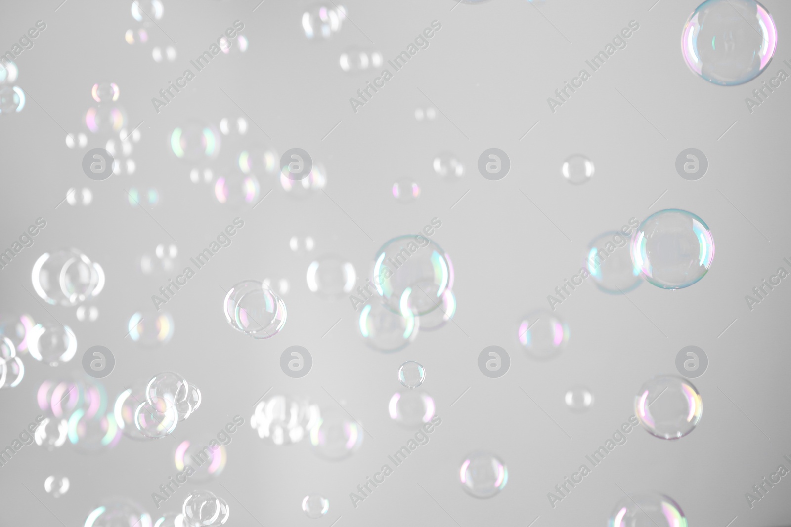 Photo of Beautiful transparent soap bubbles on grey background