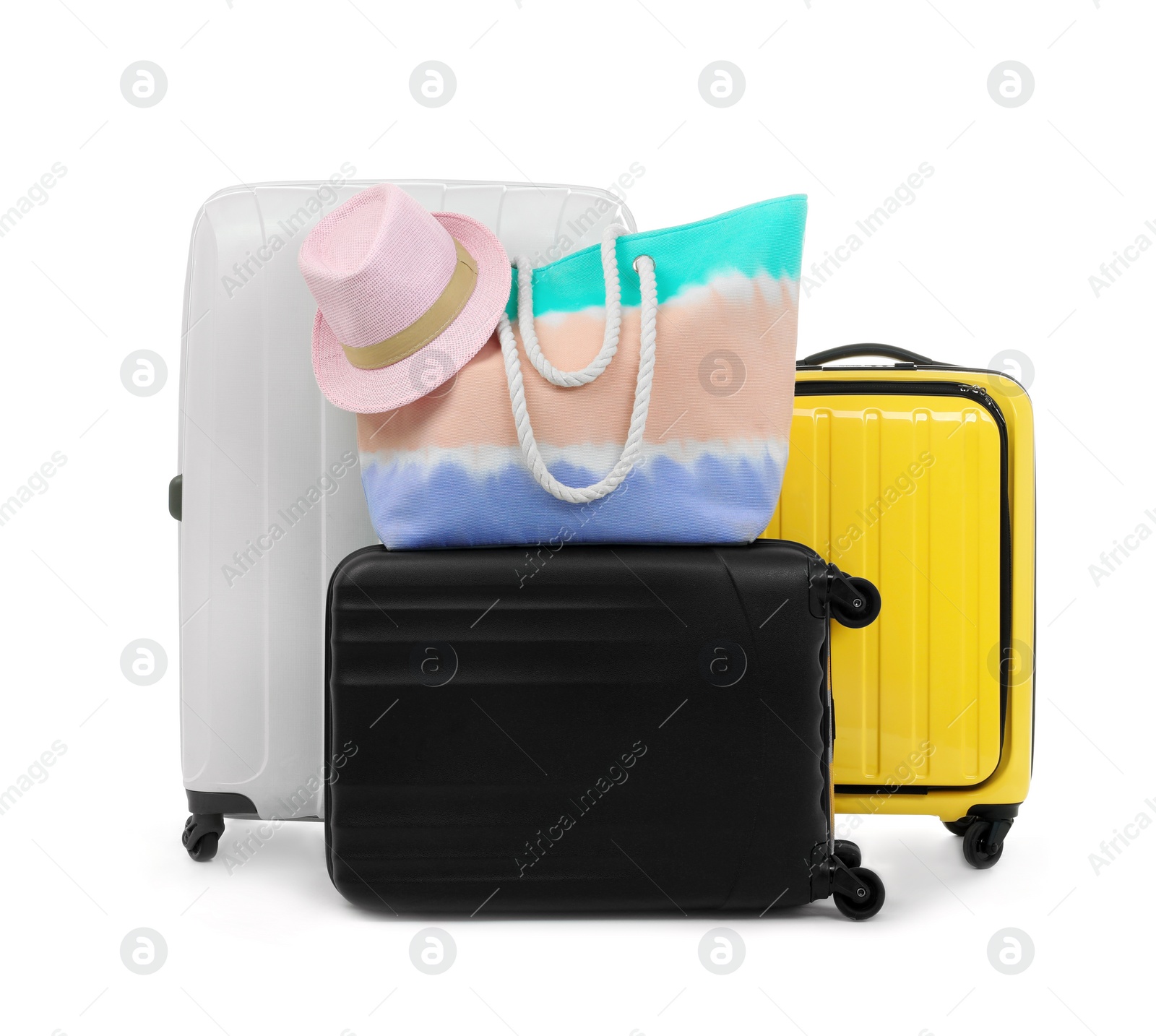 Photo of New suitcases, bag and hat packed for journey on white background