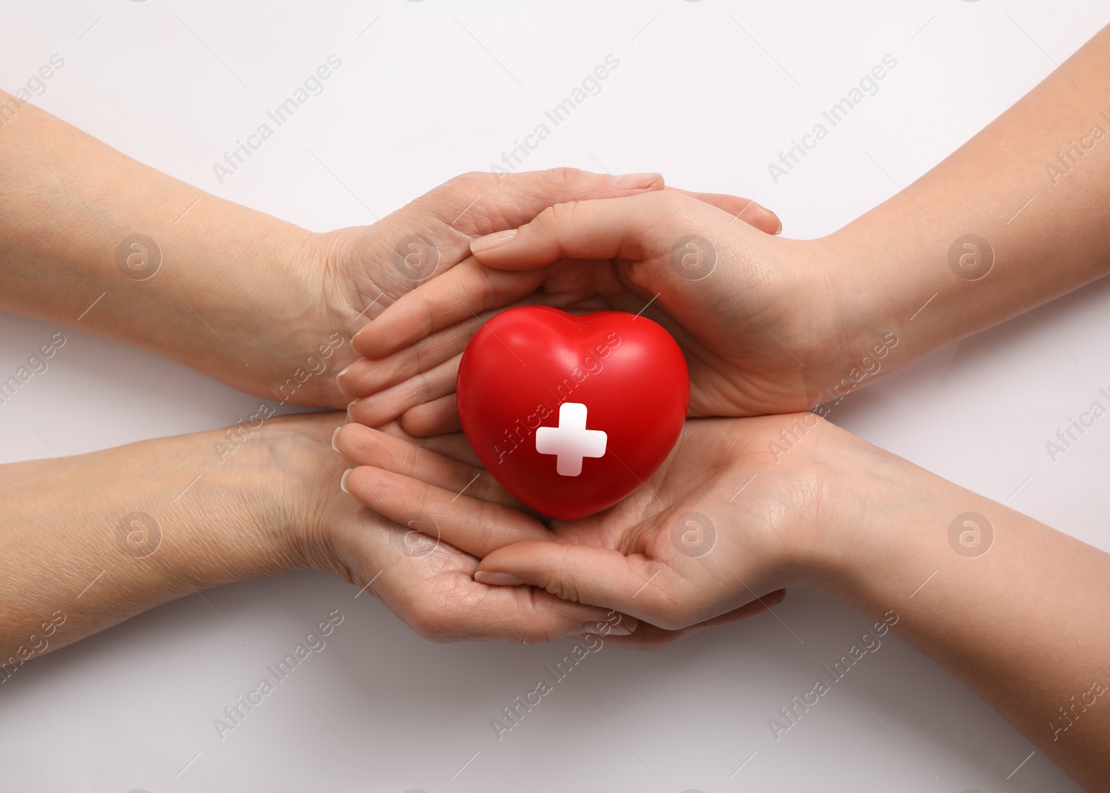 Image of Women holding red heart in hands on white background, top view. Blood donation concept