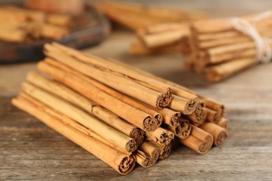 Photo of Aromatic cinnamon sticks on wooden table, closeup