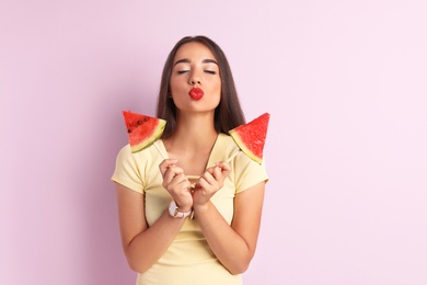 Photo of Beautiful young woman posing with watermelon on color background