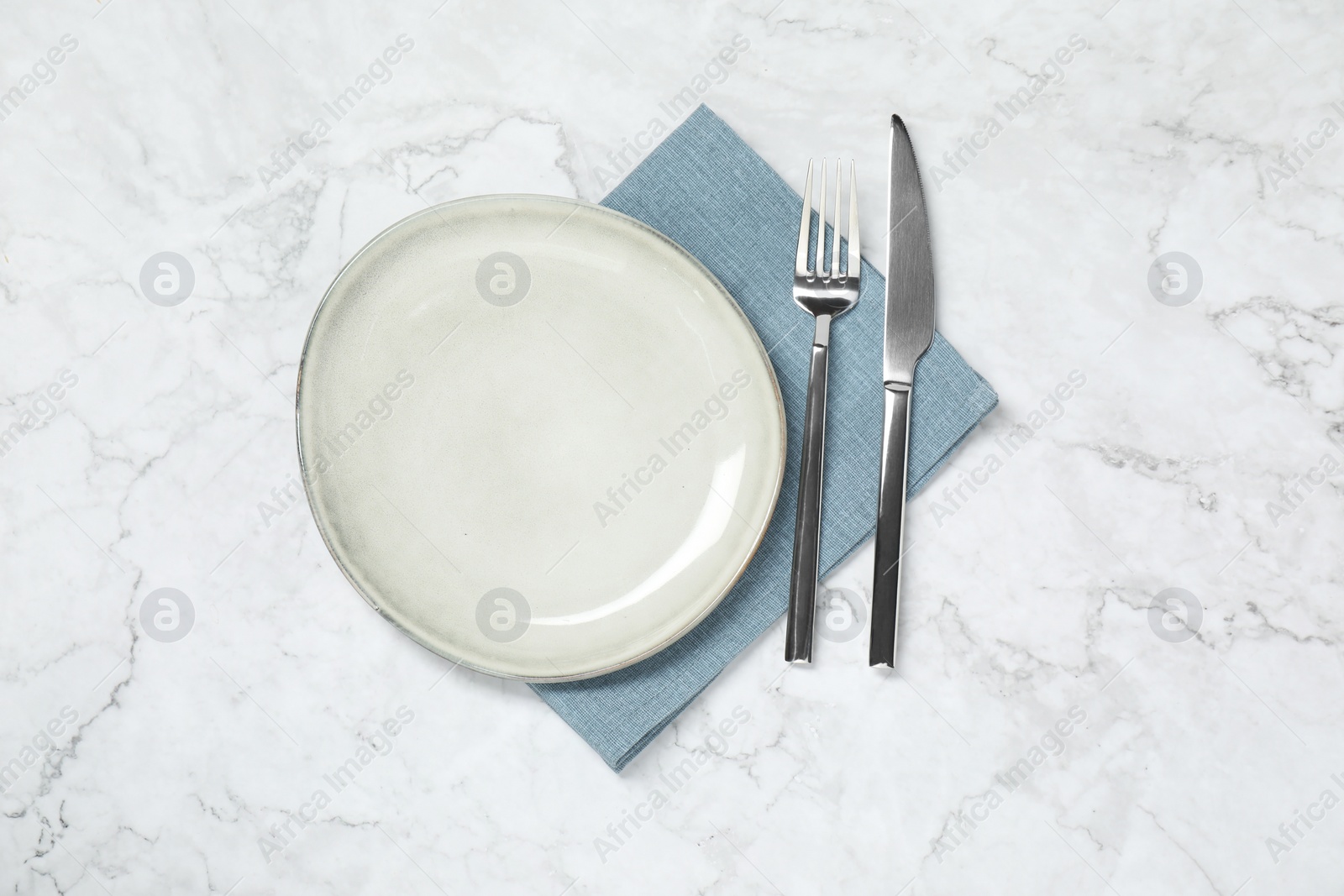 Photo of Stylish setting with elegant cutlery on white marble table, top view