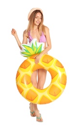 Beautiful young woman in stylish bikini with pineapple inflatable ring on white background