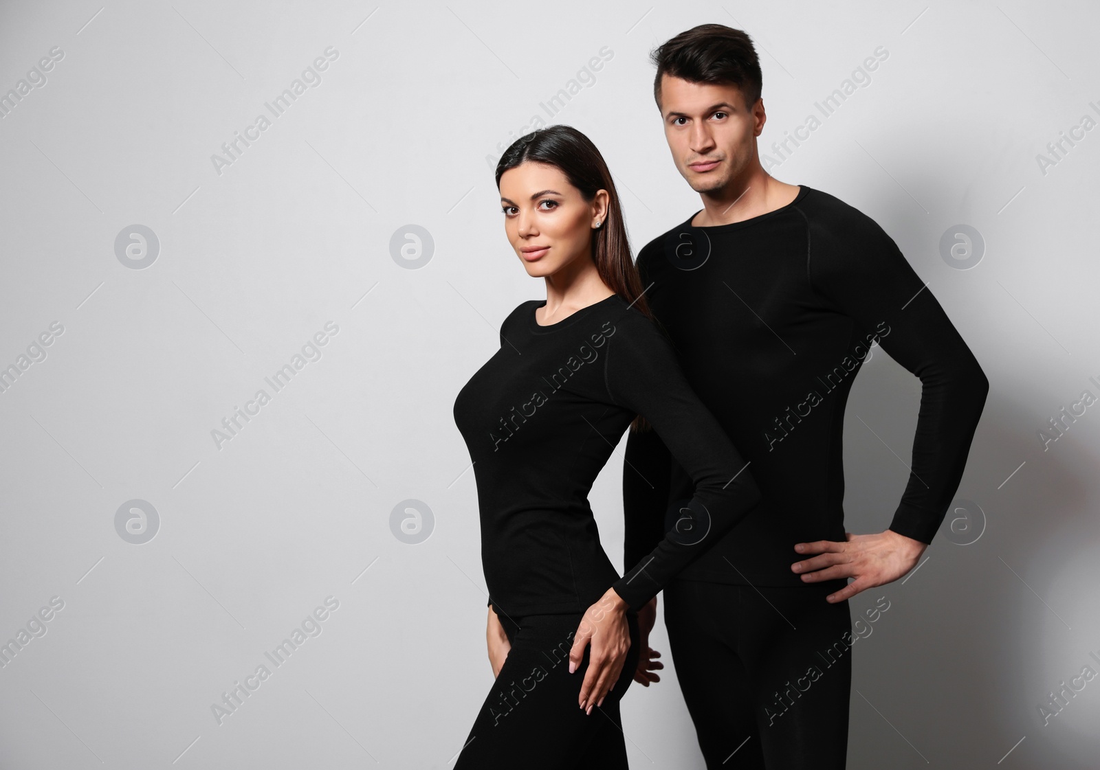 Photo of Couple wearing thermal underwear on light grey background. Space for text