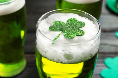 Photo of Green beer and clover on table, closeup. St. Patrick's Day celebration