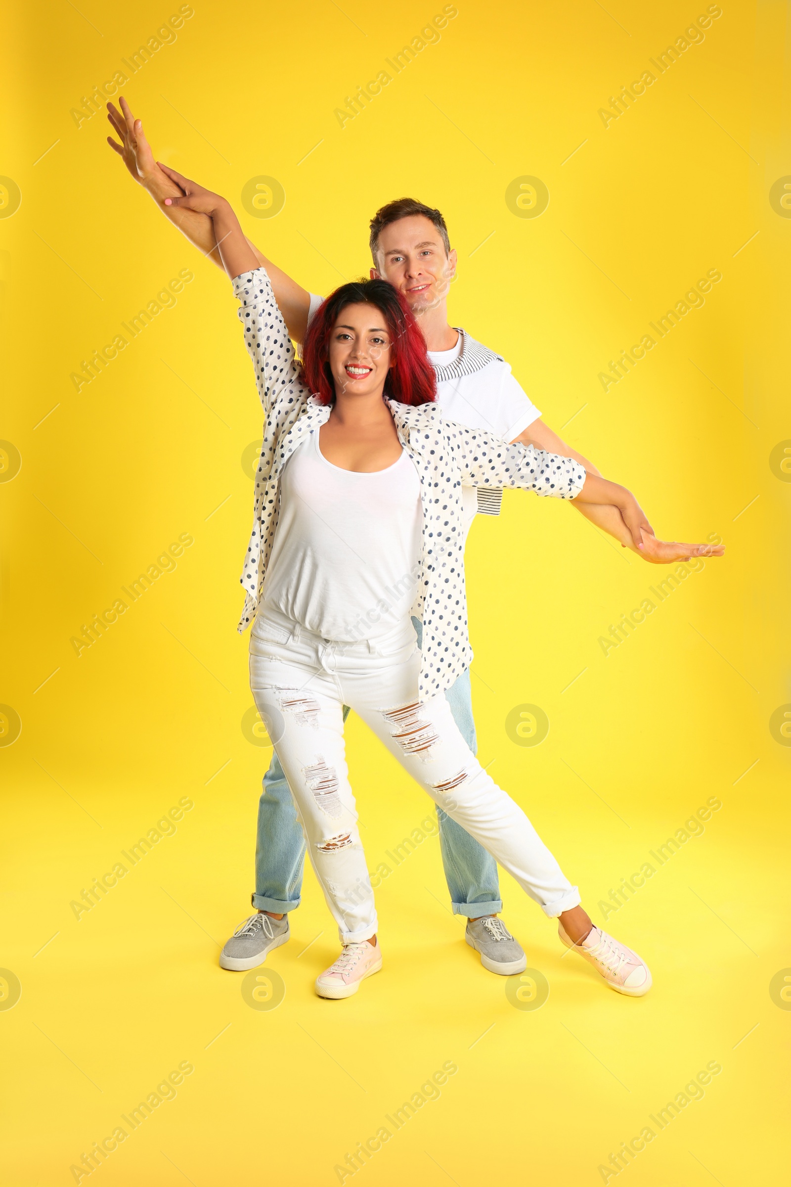 Photo of Beautiful lovely couple dancing on yellow background