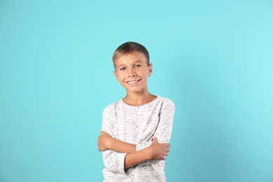 Adorable little boy in casual clothes on color background