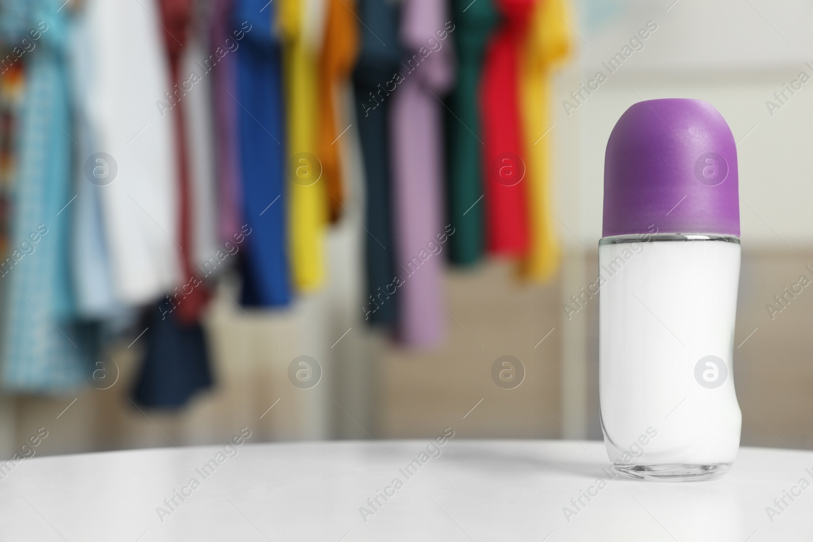 Photo of Roll-on deodorant on table against blurred background. Space for design