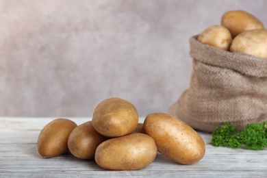 Photo of Fresh ripe organic potatoes on wooden table