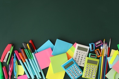 Photo of Flat lay composition with different school stationery on green chalkboard, space for text. Back to school