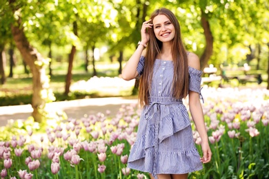 Beautiful young woman in green park on sunny spring day