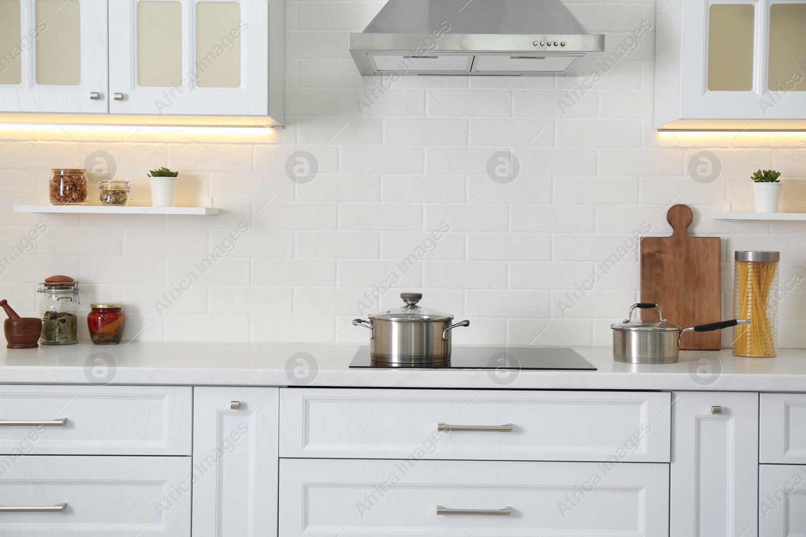 Photo of Elegant kitchen interior with modern stove and stylish furniture