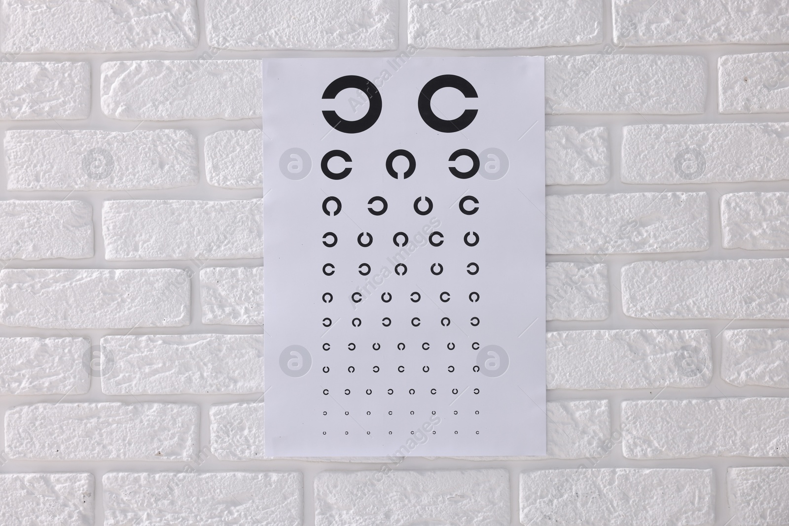 Photo of Vision test chart on white brick wall