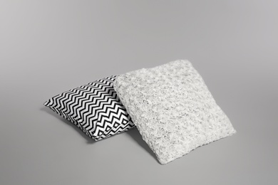 Photo of Two stylish decorative pillows on light background