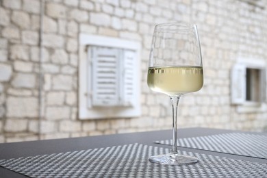 Glass of wine on black table outdoors. Space for text