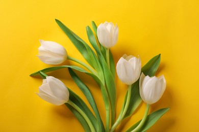 Photo of Many beautiful tulips on yellow background, flat lay