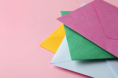 Photo of Colorful paper envelopes on pink background, closeup. Space for text