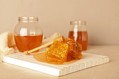 Photo of Composition with tasty honey and combs on table