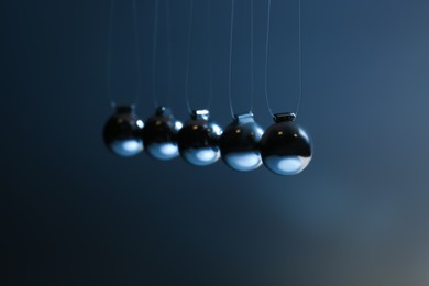 Newton's cradle on grey background, closeup. Physics law of energy conservation