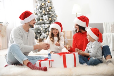 Happy family with children and Christmas gifts on floor at home