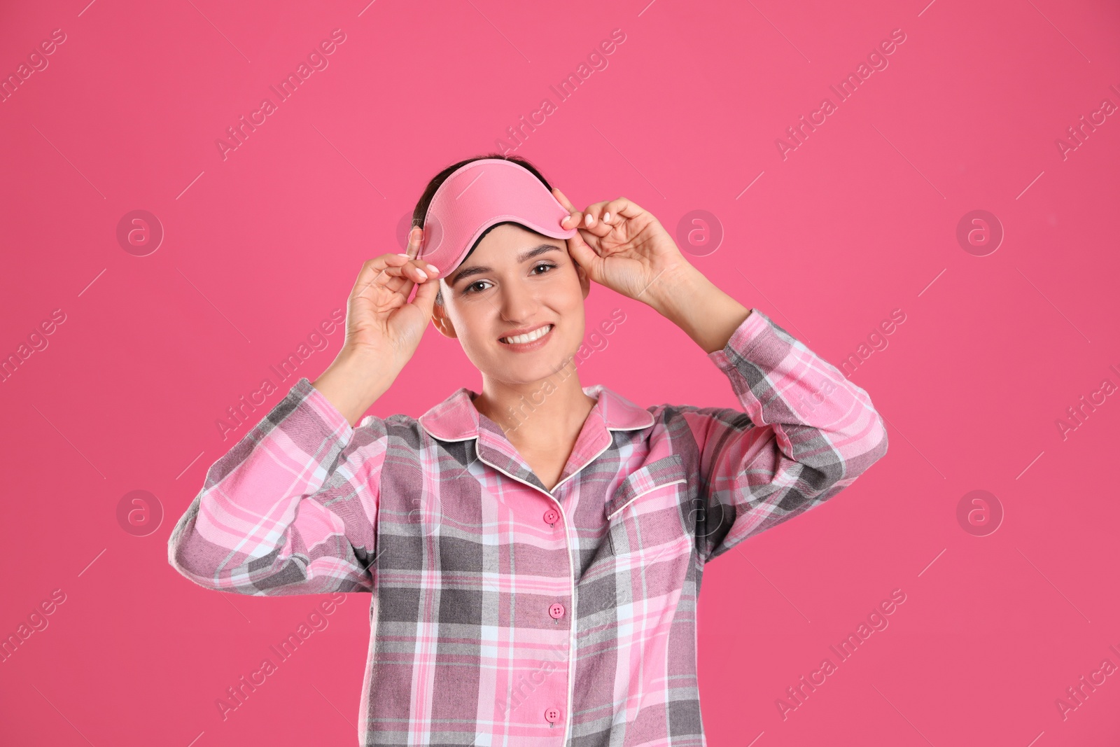 Photo of Beautiful woman wearing sleeping mask on pink background. Bedtime