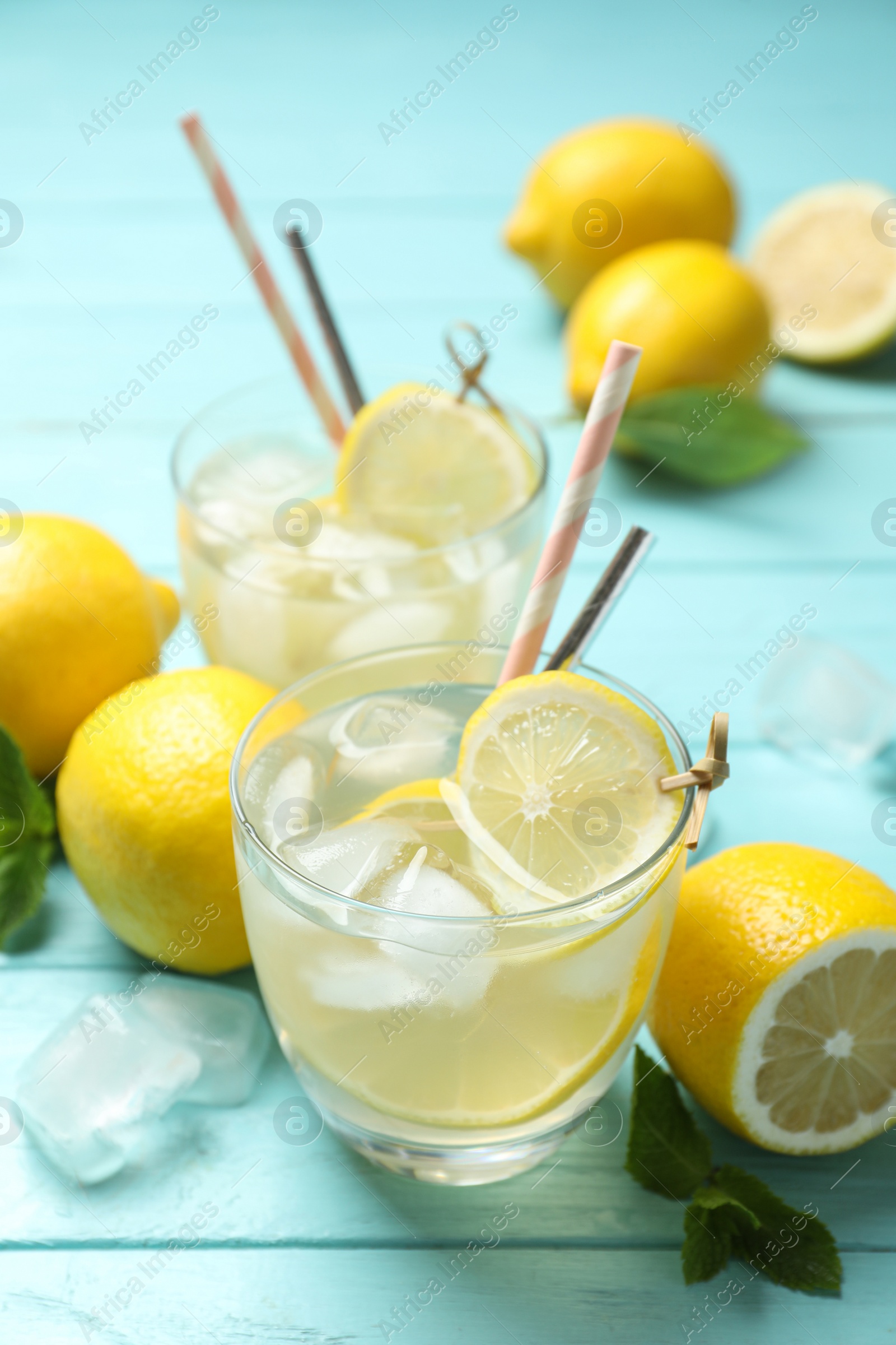 Photo of Natural lemonade and fresh fruits on light blue wooden table. Summer refreshing drink