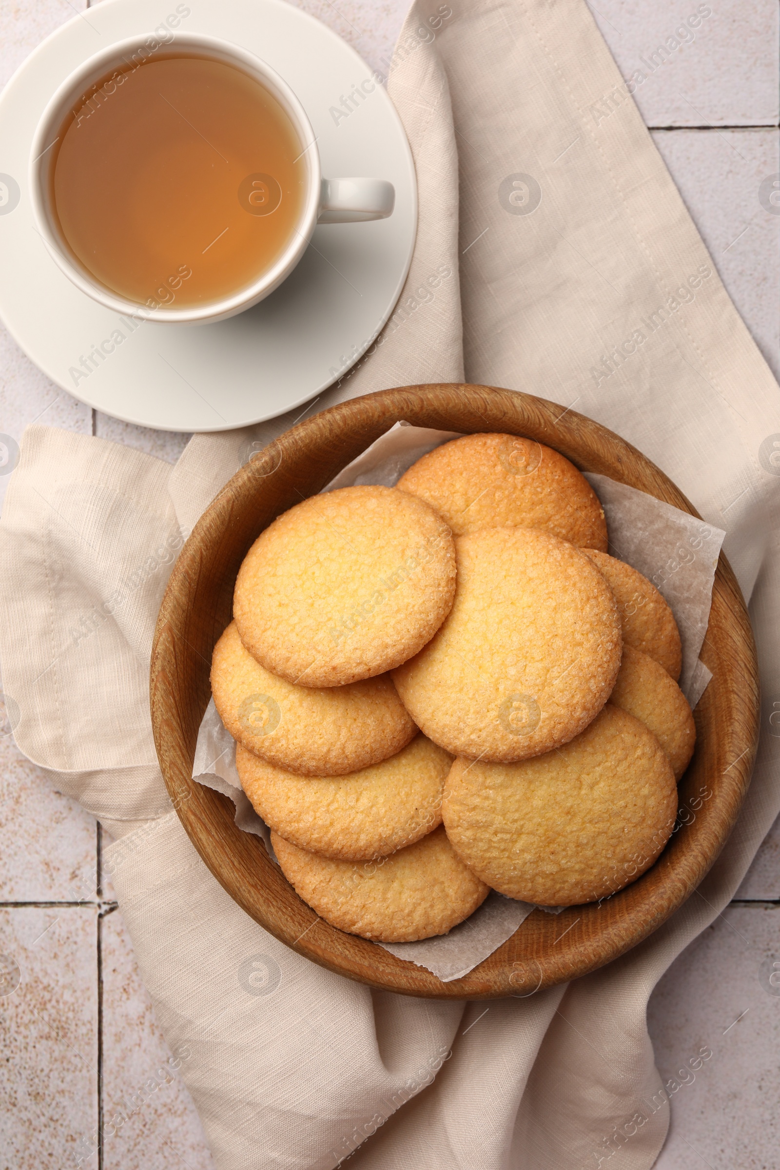 Photo of Delicious Danish butter cookies and tea on white tiled table, flat lay