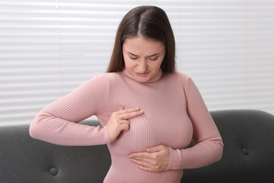 Photo of Mammology. Woman doing breast self-examination at home