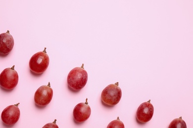 Photo of Flat lay composition with fresh ripe grapes on pink background. Space for text