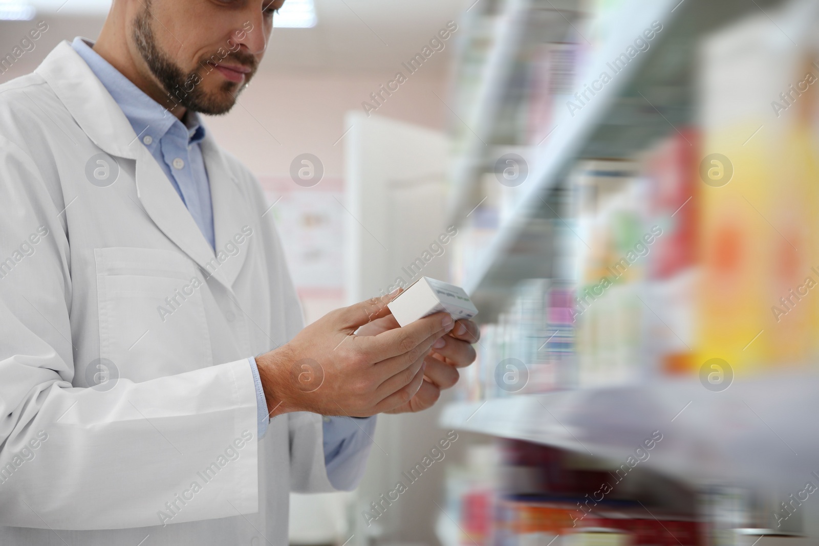 Photo of Professional pharmacist with medicine in drugstore, closeup