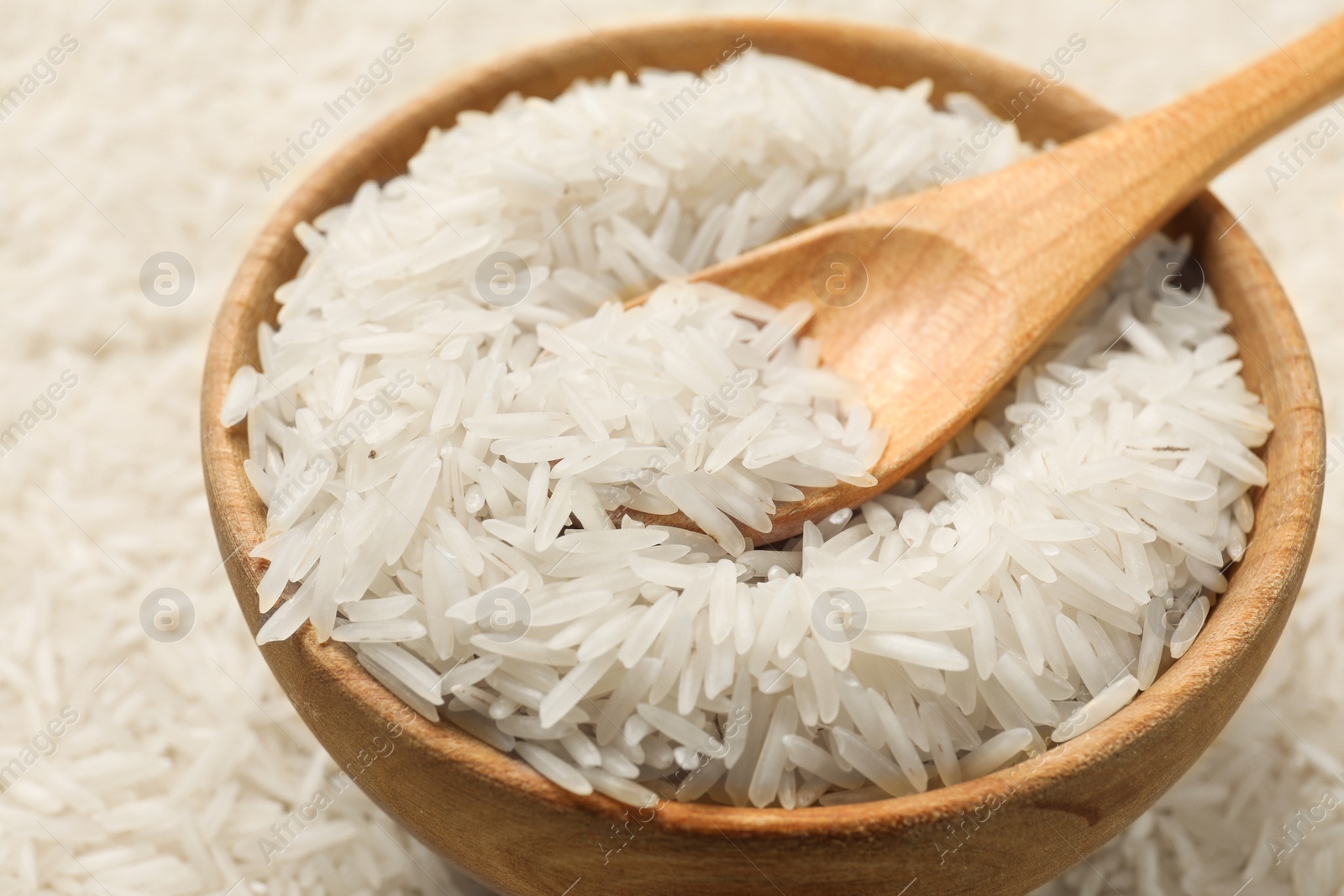 Photo of Raw basmati rice, bowl and spoon, closeup