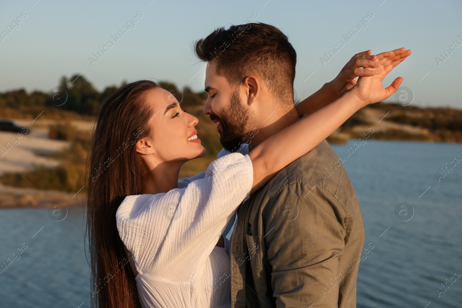 Photo of Beautiful couple dancing near river at sunset