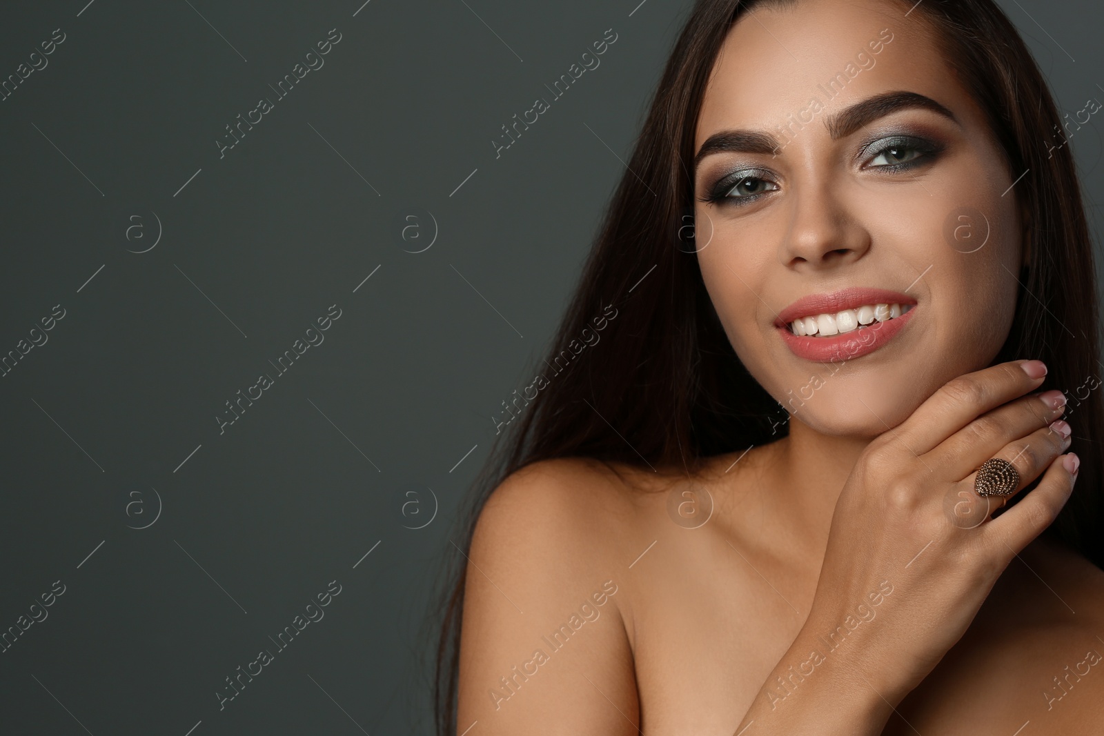 Photo of Portrait of beautiful woman with stylish makeup on gray background. Space for text