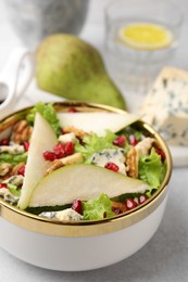 Photo of Delicious pear salad in bowl on light table, closeup