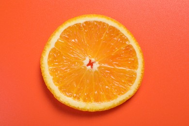Photo of Slice of juicy orange on terracotta background, top view
