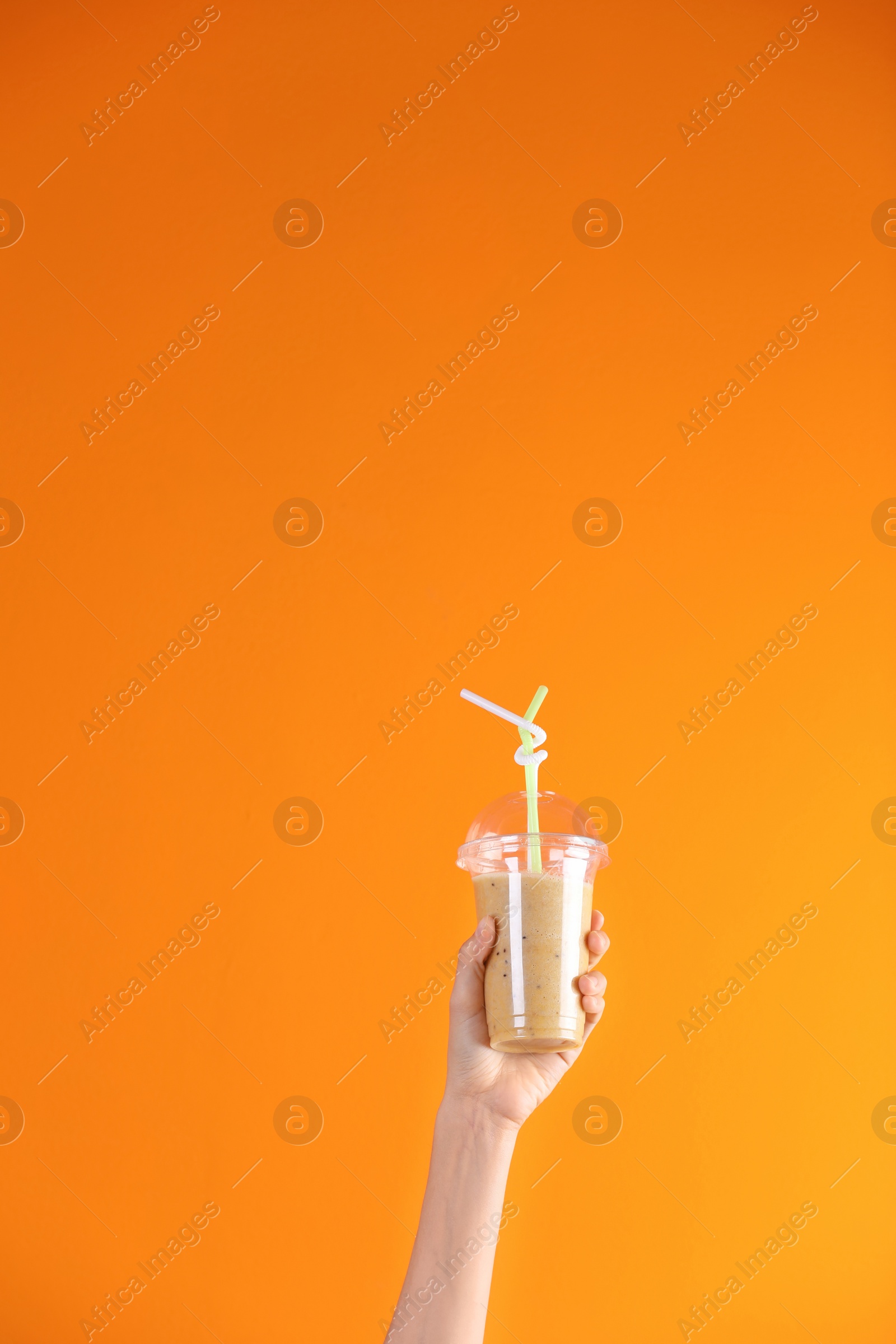 Photo of Young woman holding plastic cup of healthy smoothie on color background