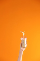 Young woman holding plastic cup of healthy smoothie on color background