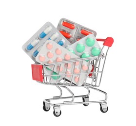 Blisters with different pills in mini shopping cart on white background