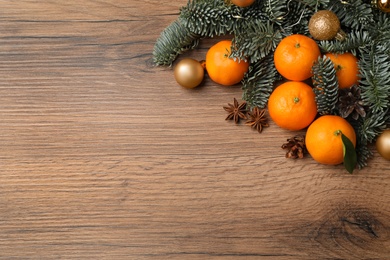 Christmas composition with tangerines on wooden background, flat lay. Space for text