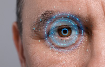 Image of Vision test. Man and digital scheme focused on his eye against grey background, closeup