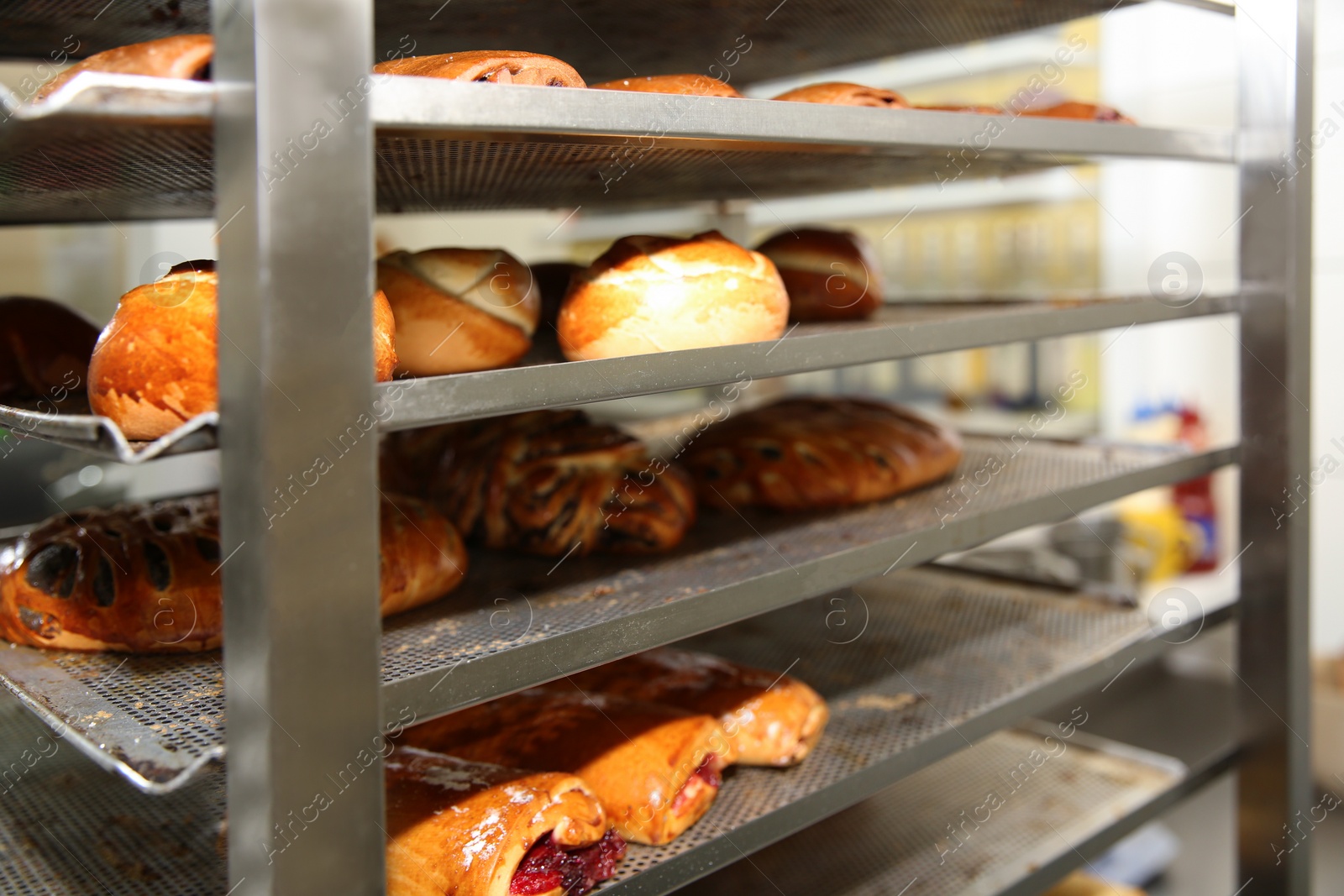 Photo of Rack with fresh pastries in bakery workshop, closeup