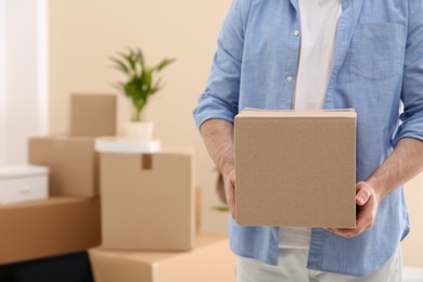 Man holding moving box in new office, closeup. Space for text