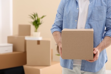 Photo of Man holding moving box in new office, closeup. Space for text