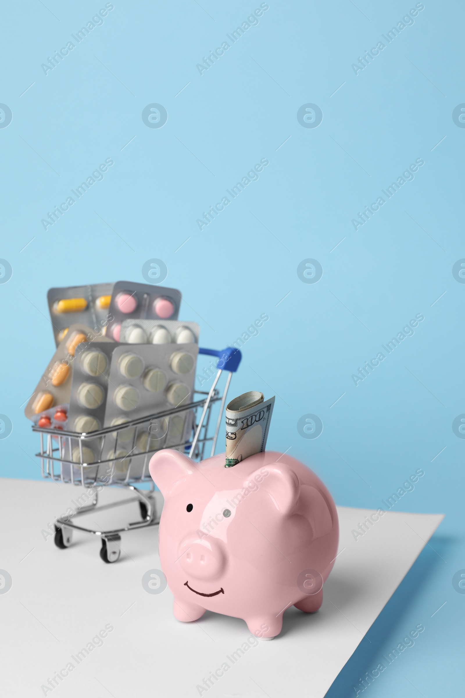 Photo of Piggy bank, pills and money on colorful background, space for text. Medical insurance