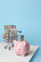 Photo of Piggy bank, pills and money on colorful background, space for text. Medical insurance
